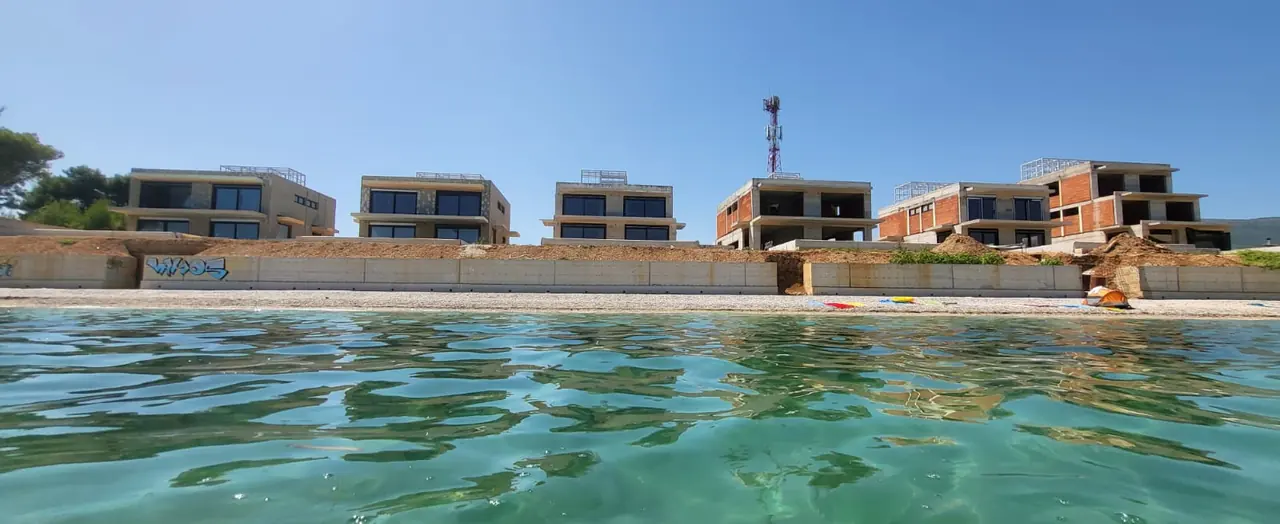 Photograph, September 2026 — The same row, from the water
